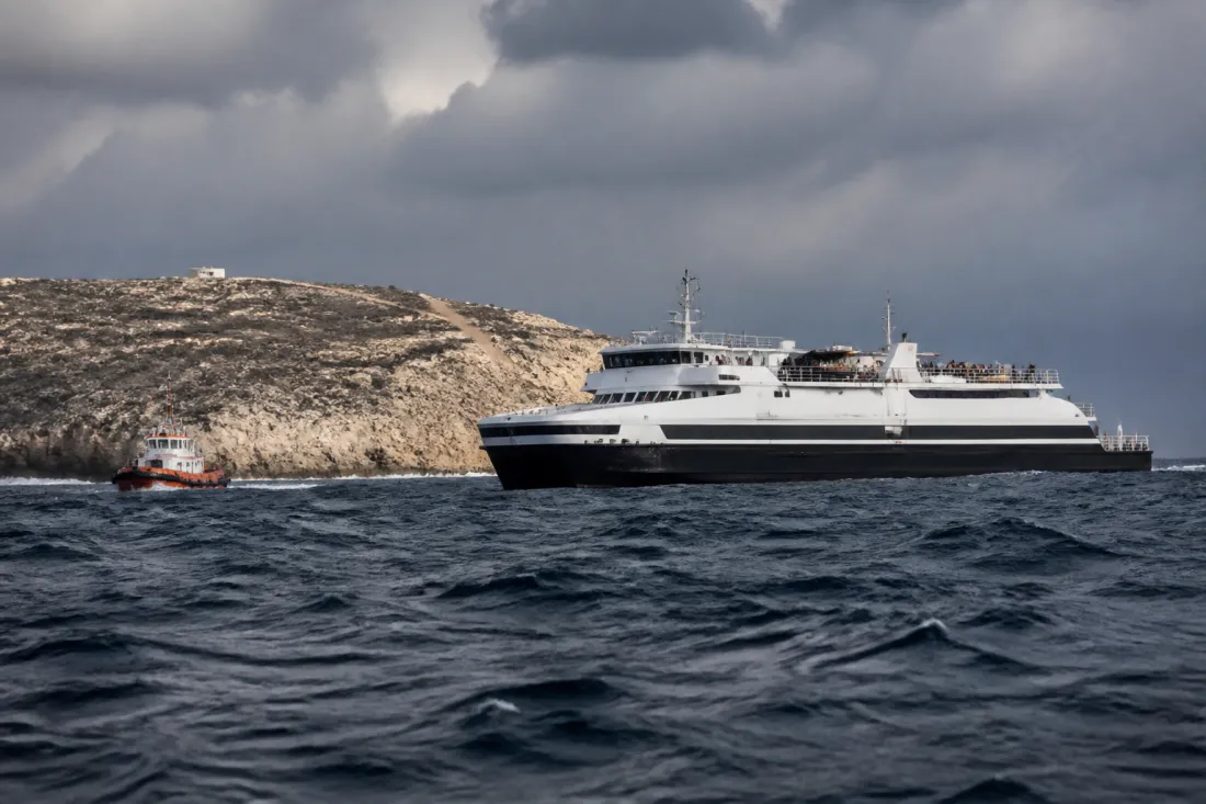 Rettungsboot und Fähre vor felsiger Küste bei Zypern bei rauer See