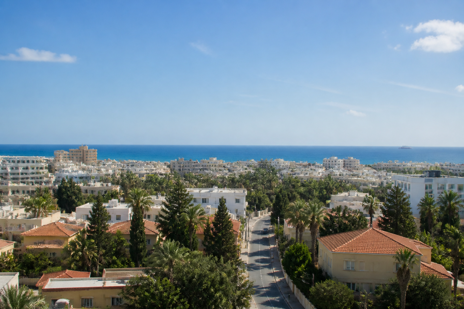 Blick über Larnaka auf Zypern mit Mittelmeer, moderner Stadt und ruhiger Küstenstraße bei klarer Abendstimmung