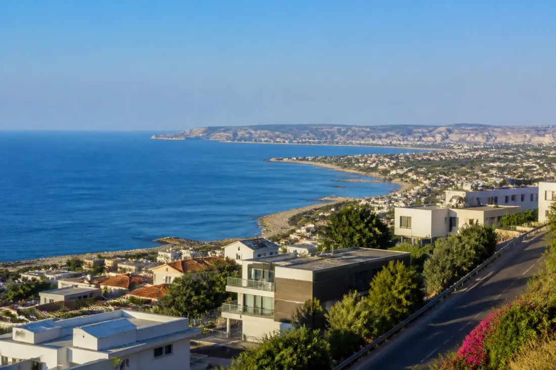 Blick auf die Küste bei Limassol auf Zypern mit ruhigem Meer und moderner Stadt im Hintergrund als Symbol für Sicherheit und Alltag