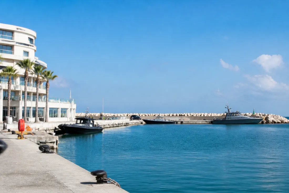 Hafen von Limassol auf Zypern mit Küstenlinie, Meer und Sicherheitsbooten im Hintergrund