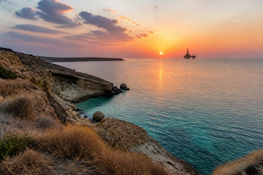 Offshore-Energieanlage vor der Küste Zyperns bei Sonnenuntergang als Symbol für Gas, Infrastruktur und Auswanderungsplanung